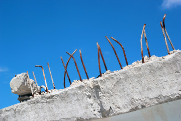 Rusty reinforcing bars sticking out of demolished concrete block