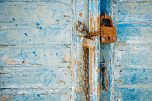 Old Rusty Padlock And Chain On Weathered Textured Door