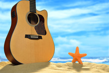 Acoustic Guitar And Starfish On The Beach With Blue Sea And Sky