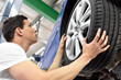 change a tyre // Reifenwechsel in einer Werkstatt durch Monteur 