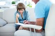 © WavebreakmediaMicro - Doctor writing on notepad while consulting female patient