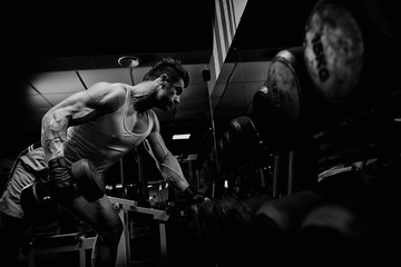 Wall Mural - very power athletic guy standing with barbell, workout in the gy