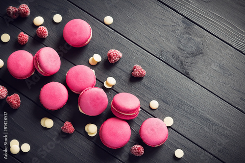 Photographie Macarons framboise sur fond de bois noir