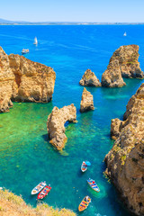 Wall Mural - View of fishing boats on sea at Ponta da Piedade rocky coast, Algarve region, Portugal