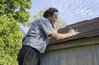Insurance Adjuster On Cell Phone Calculating Roof Repair Costs