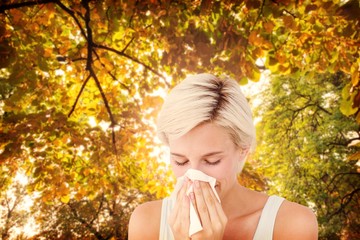 Poster - Composite image of sick woman blowing her nose
