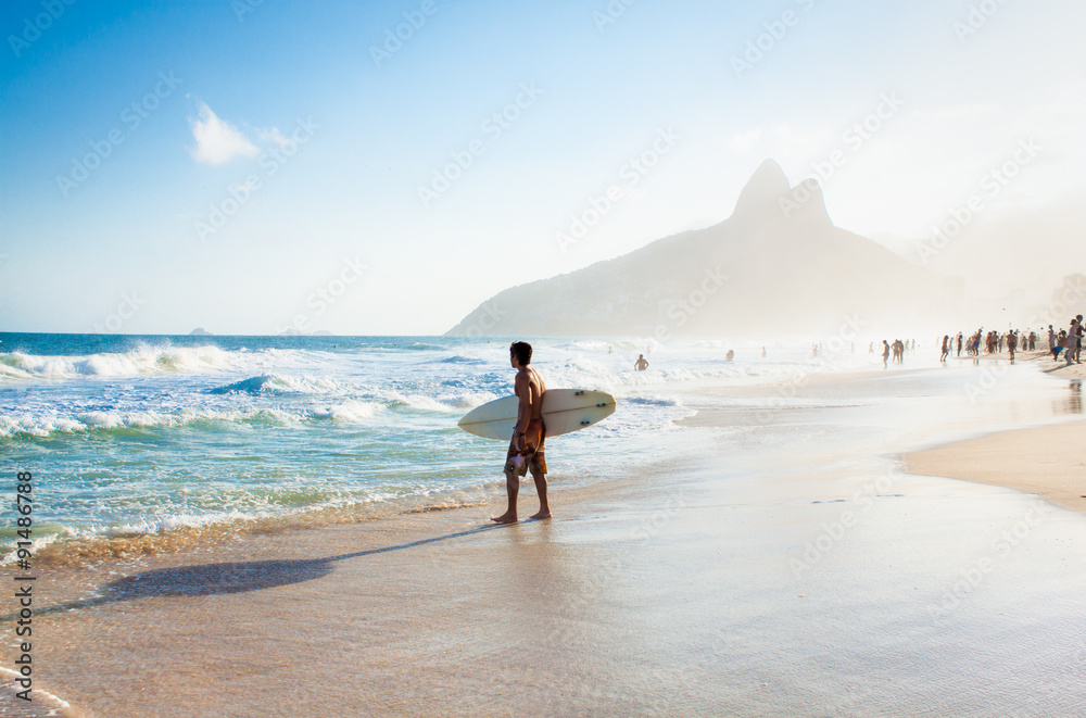 Brazilian surfer walking with surfboard toward Two Brothers Moun - obrazy, fototapety, plakaty 