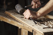 © guerrieroale - carpenter hands working with a chisel and hammer