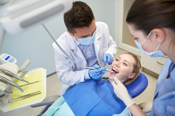 Sticker - male dentist treating female patient teeth