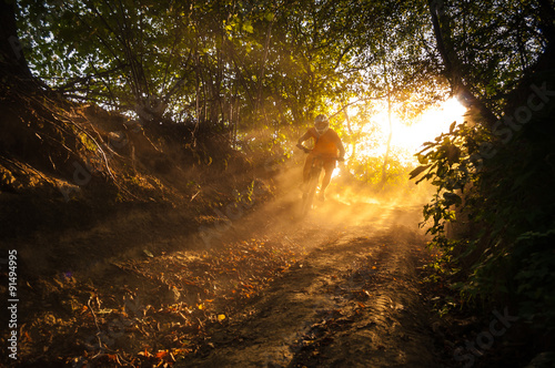 Fotografía Downhill mountain biker at sunset