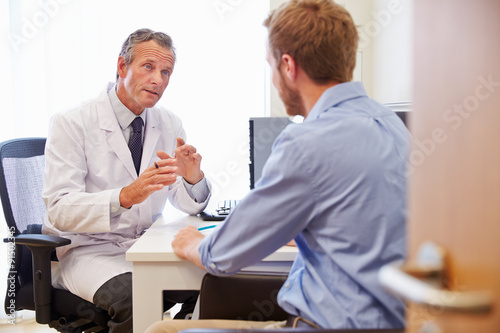 Fotografía Paciente de sexo masculino que tiene consulta con el doctor en la oficina