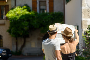 a young couple looking at a map, rear view