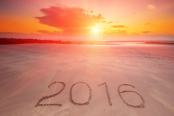  Inscription of the year 2016 written in the wet yellow beach sand