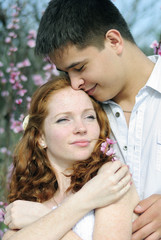 Fototapete - beautiful young couple in love among the flowering trees