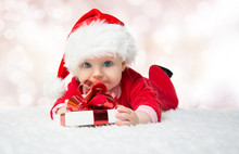 Beautiful Little Baby Celebrates Christmas. New Year's Holidays. Baby In A Christmas Costume With Gift