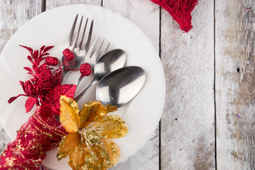 Christmas table setting in gold and red tone on wooden table