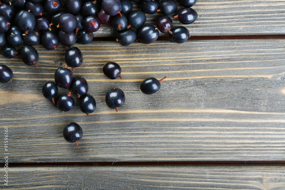 Heap of wild black currant on wooden table close up