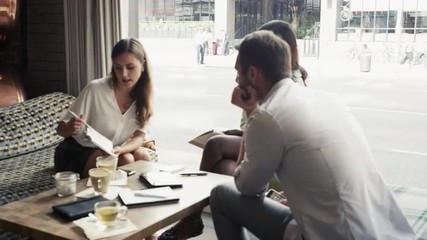 Business people meeting in cafe using digital tablet
