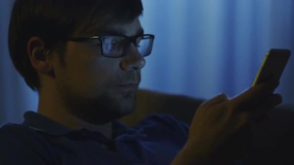 man is taking the phone from table to write a message at night