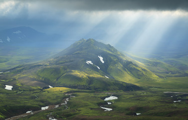 Wall Mural - Sun breaking through the clouds on a mountain on the Laugavegur hiking trail on Iceland.