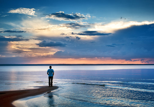 Alone man at sea in sunset