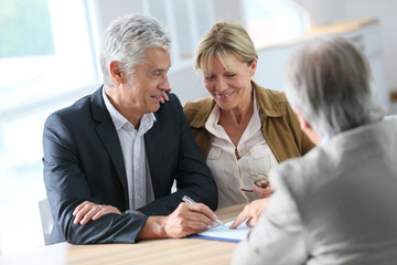 Senior couple meeting real-estate agent for investment