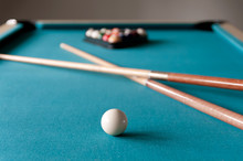 Two Cue Billiards Lie On The Table