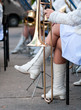 trombone stands near the feet girl in white boots