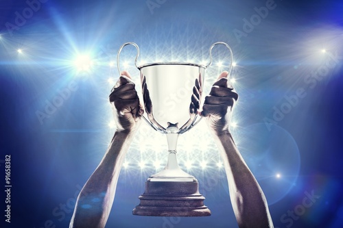 Fotografie, Tablou Composite image of cropped hand of athlete holding trophy