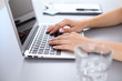 © rogerphoto - Close up of business woman hands typing on laptop computer