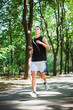 © kurapatka - young caucasian male running in park. Teenager jogging in park