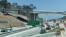 Wide View Of Heavy Equipment Tearing Down Part Of A Bridge Over The 405 Freeway In Los Angles.