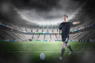 Composite image of rugby player doing a drop kick