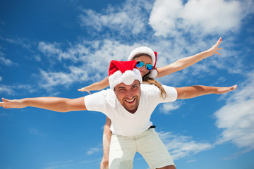 Happy smiling couple piggyback together, celebrating Christmas