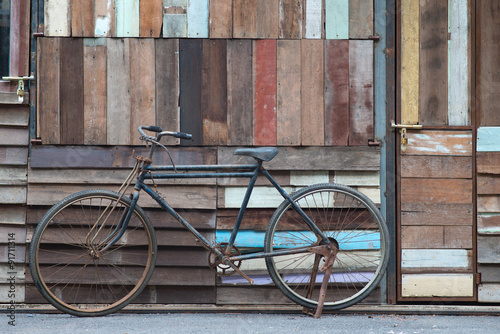 Obraz w ramie Vintage bicycle leaning against wooden wall.