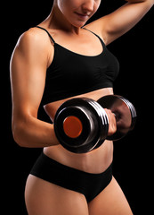 Wall Mural - Athletic girl with dumbbells in hand.