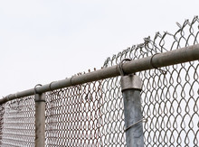 Top Of Old Chain-link Fence And Posts On White