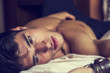 © theartofphoto - Shirtless sexy male model lying alone on his bed