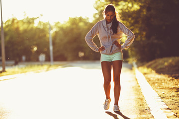 Tired female runner taking a break after  jogging .