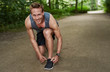 © Flamingo Images - Smiling Fit Man Fixing his Shoelace at the Park