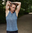 © Flamingo Images - Man Stretching Arms Behind his Head at the Park