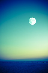 full moon over beach at dusk