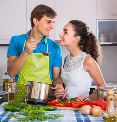 Couple cooking vegetables at kitchen