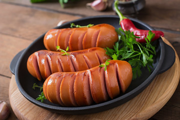 Wall Mural - Sausages on the grill pan on the wooden background