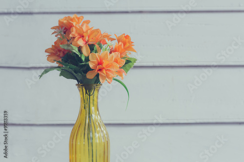 Colorful flower in transparent yellow vase