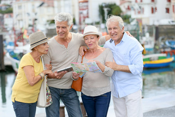 Wall Mural - Senior couples looking at map on traveling journey