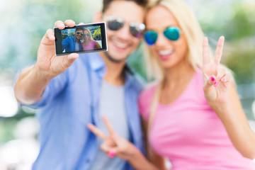 Wall Mural - Couple taking a selfie with smartphone