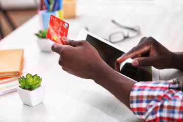 Sticker - African American male hands with tablet and credit card at workplace