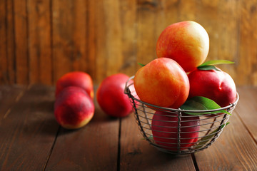 Poster - Fresh peaches in wicker basket on wooden background