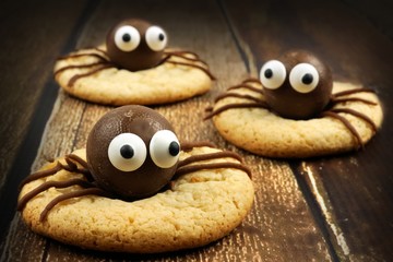 Group of chocolate Halloween spider cookies on rustic old wood